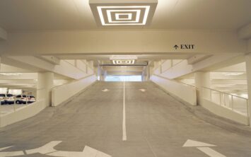 A ramp leading down to the underground parking area is being built on the ground floor in an enclosed space. Will this be included in the building's floor area?